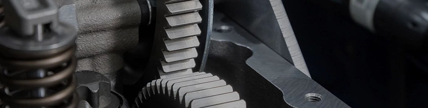 Nahaufnahme von ineinandergreifenden Metallzahnrädern und Federn in einer mechanischen Vorrichtung.