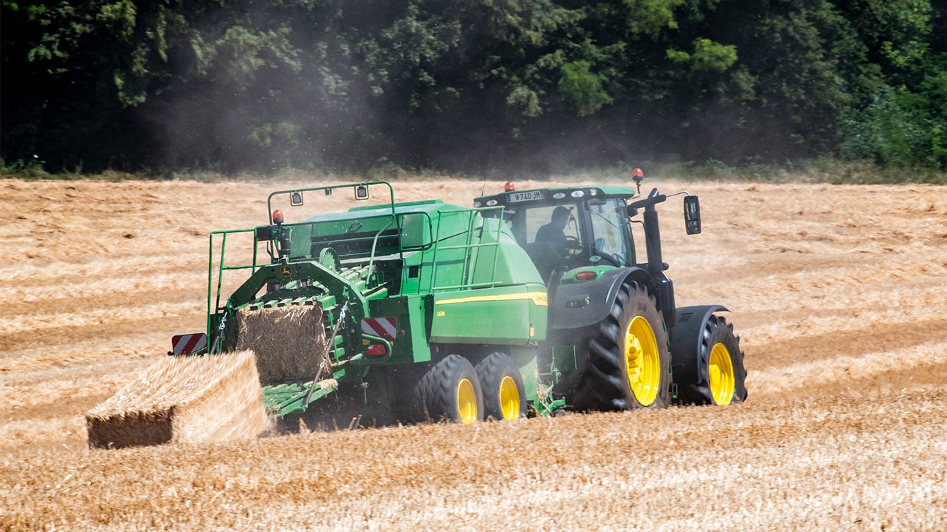 John Deere Großpackenpresse L634 mit Traktor 6R in Stroh