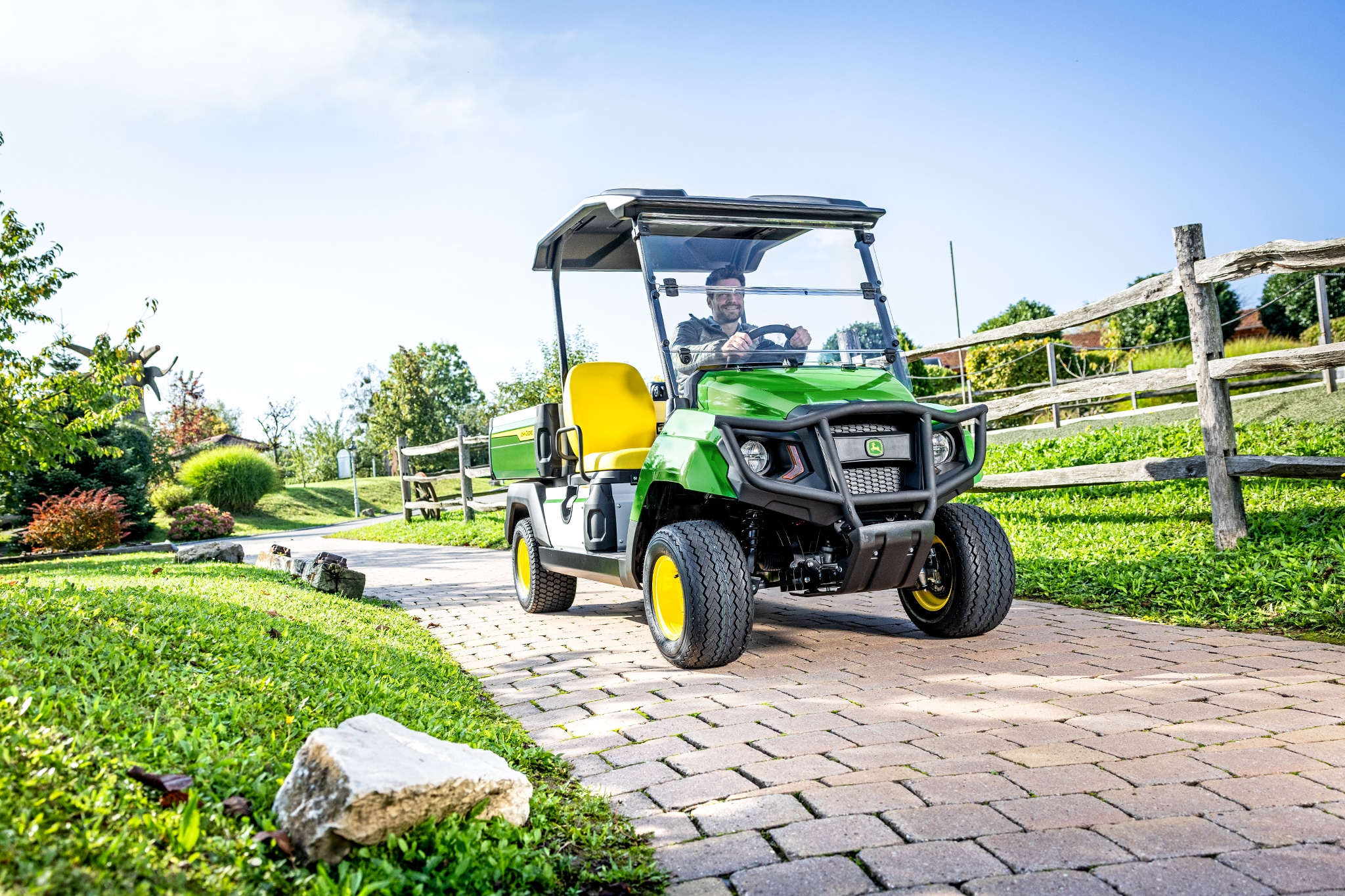 Gator GS Nutzfahrzeug fährt auf einem befestigten Weg in einer Landschaftsanlage Gator GS Nutzfahrzeug fährt auf einem befestigten Weg in einer Landschaftsanlage