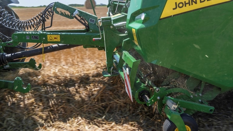 Die hohe Aufnahmekapazität einer John Deere Ballenpresse VR, die eine riesige Strohschwade aufnimmt.